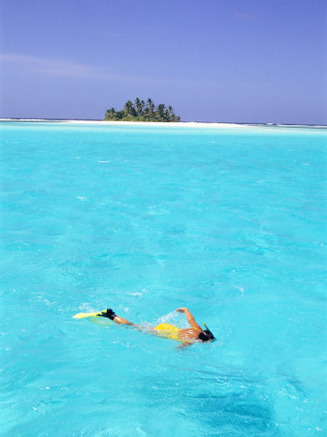 Woman Snorkelling at Sea Surface,Cocos Keeling Island in Background, Indian Ocean, Australia